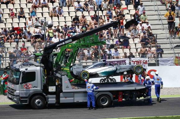 Track workers recover the crashed car of Mercedes Formula One driver Hamilton from Great Britain during the qualifying for the German F1 Grand Prix at the Hockenheim racing circuit